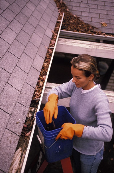 woman cleaning gutters