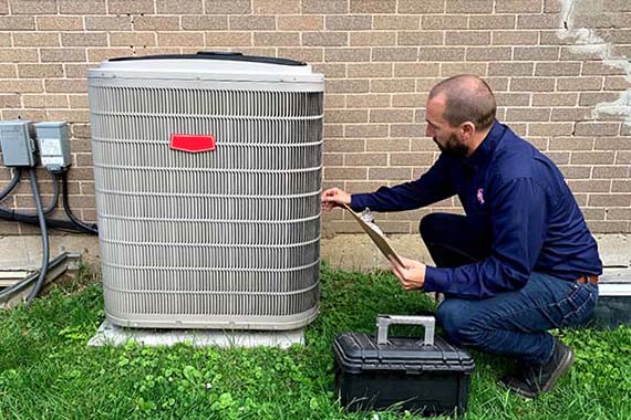 Technician performing Air Conditioner Maintenance